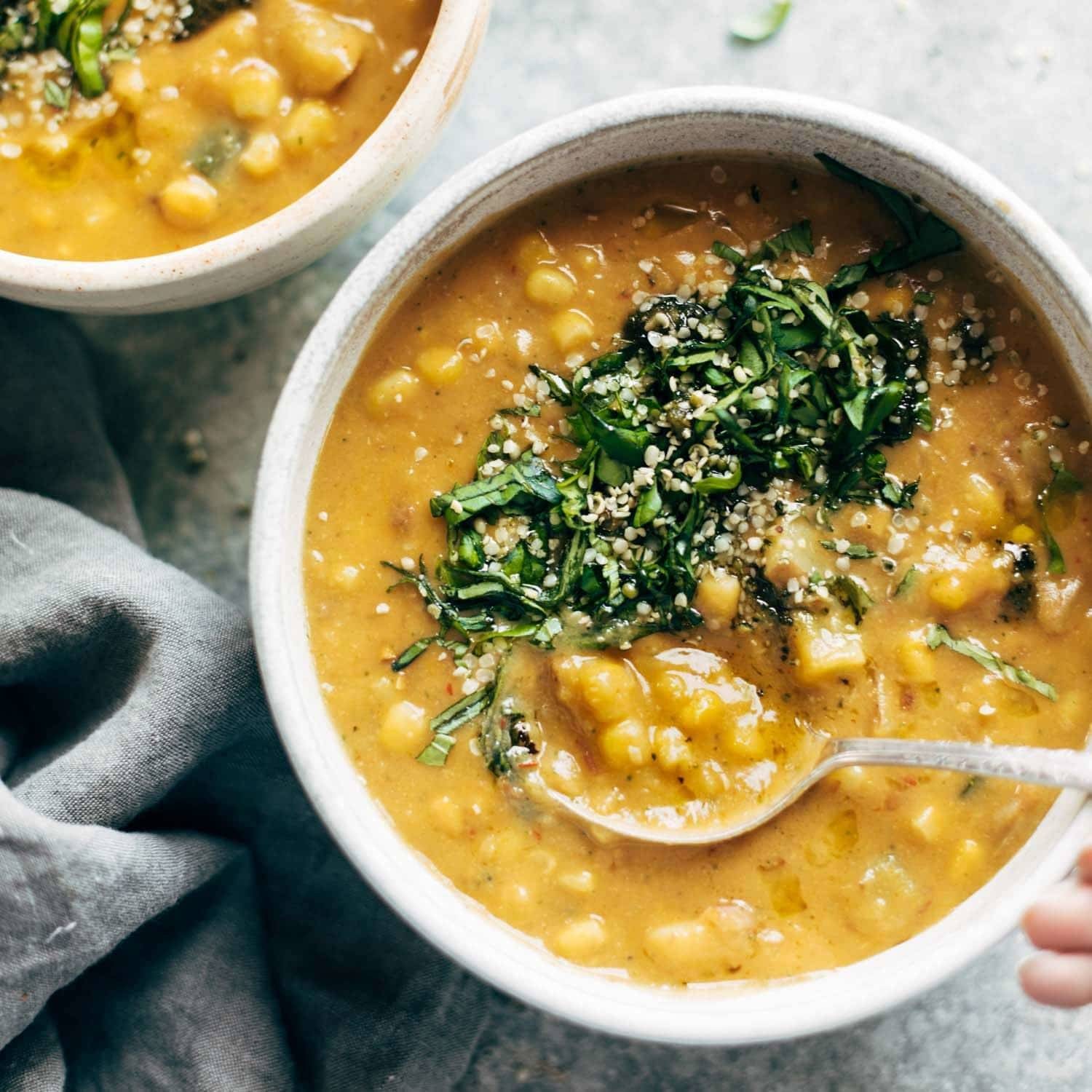 Soup in two bowls with herb topping.