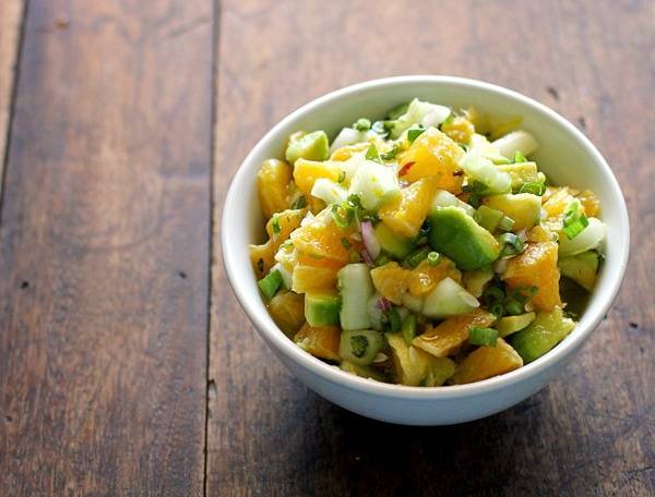 Avocado cucumber grapefruit salad in a white bowl.
