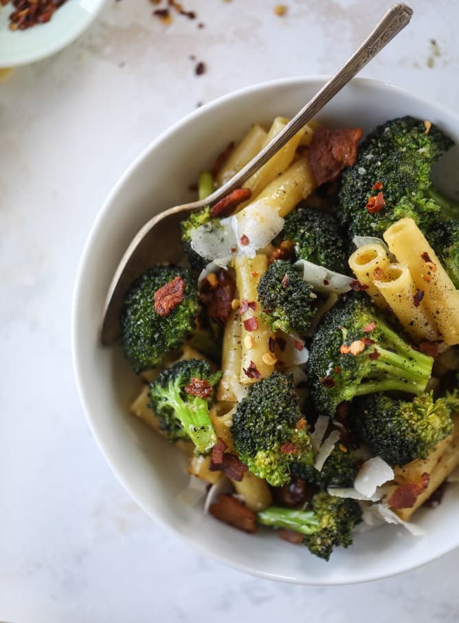 This is the easiest weeknight bacon broccoli pasta that can come together in minutes! Super flavorful and filled with crispy bacon, fresh broccoli, shaved parmesan and crushed red pepper, it's delicious on its own or as a base for more veggies or meat! I howsweeteats.com #bacon #broccoli #pasta #easy #dinner #recipes