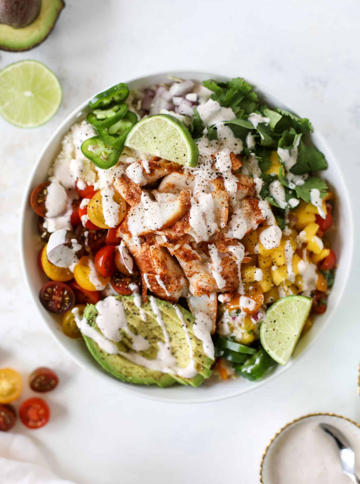 These fish taco bowls are an amazing weeknight meal idea! Napa cabbage for the base, a homemade chipotle crema, avocado, mango pico de gallo, spicy broiled white fish and lots of lime. Major flavor explosion and so easy too! I howsweeteats.com #fish #taco #bowls #spicy #healthy #dinner