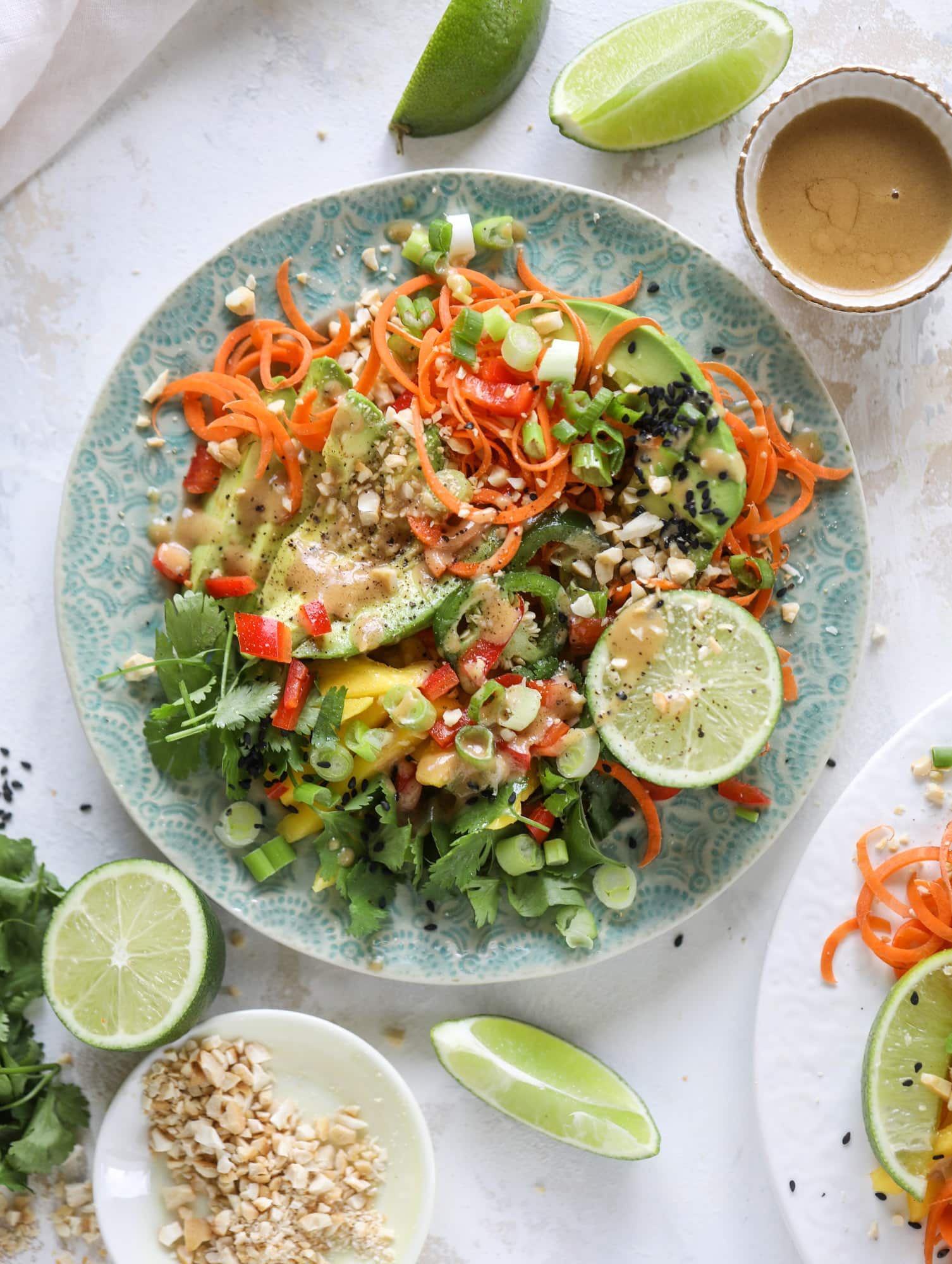 This thai avocado salad is loaded with mango, red pepper, carrots, green onions and drizzled with a peanut butter vinaigrette. It's an amazing side salad or a fabulous dinner salad - add on chickpeas or shrimp or chicken if you wish! I howsweeteats.com #thai #avocado #salad #peanutbutter #mango #lime