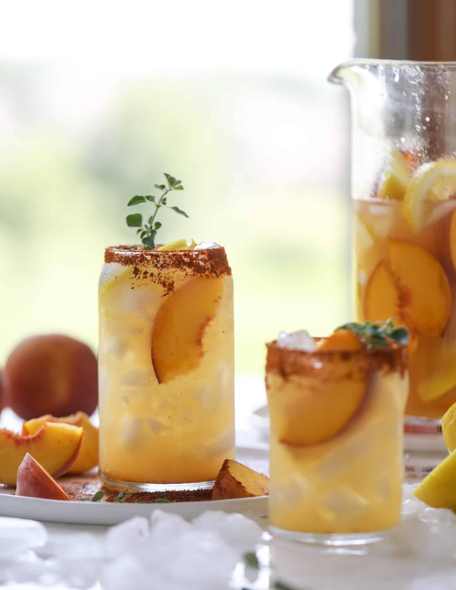 This peach lemonade is super refreshing and a bit spicy for a hot and sunny summer day. It's sweet and fresh and the rim is dipped in a cajun seasoning, bringing the best bite of heat to this perfect summer drink. So fresh! I howsweeteats.com #peach #lemonade #cajun #summer #mocktail #lemon #drink