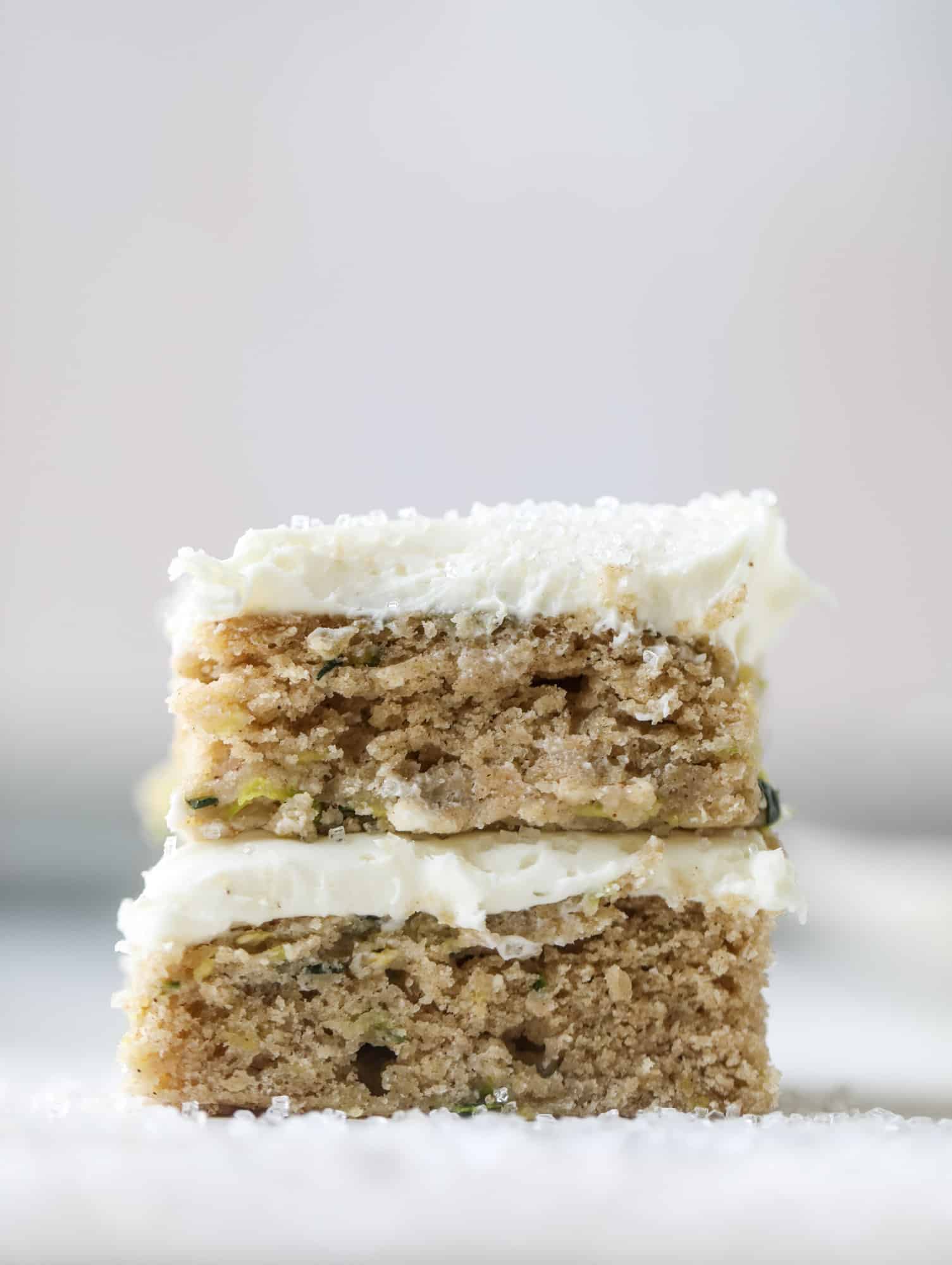These zucchini bars with cream cheese icing are a fun twist on zucchini bread! Zucchini bars are super easy to make, have a little spice and a lot of flavor, topped with the creamiest cream cheese frosting. Delicious and simple! I howsweeteats.com #zucchini #bars #cream #cheese #icing #dessert