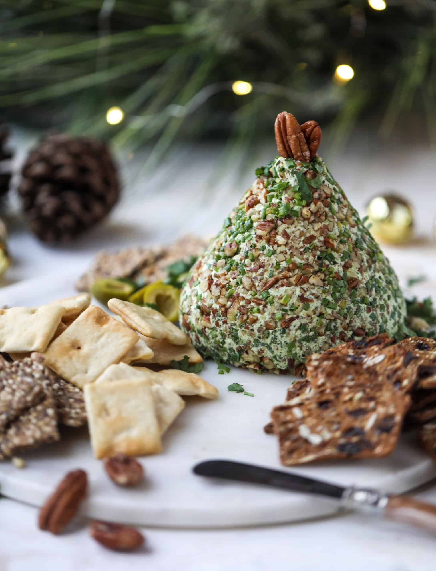 This green goddess cheese ball is the perfect party snack! You can make it ahead of time and shape it into a cute tree for a festive look. Serve it with crispy crackers and pita chips! I howsweeteats.com #greengoddess #cheeseball