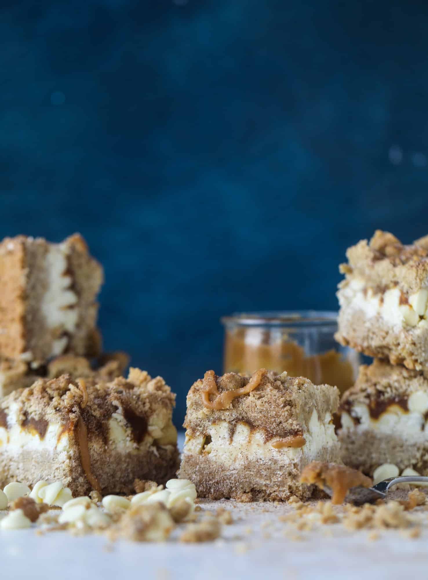 These snickerdoodle caramelitas have a layer of chewy, cinnamon sugared oatmeal bar topped with cream white chocolate and more crumbly, chewy oatmeal bites. They are super delicious and festive! I howsweeteats.com #snickerdoodle #caramelitas