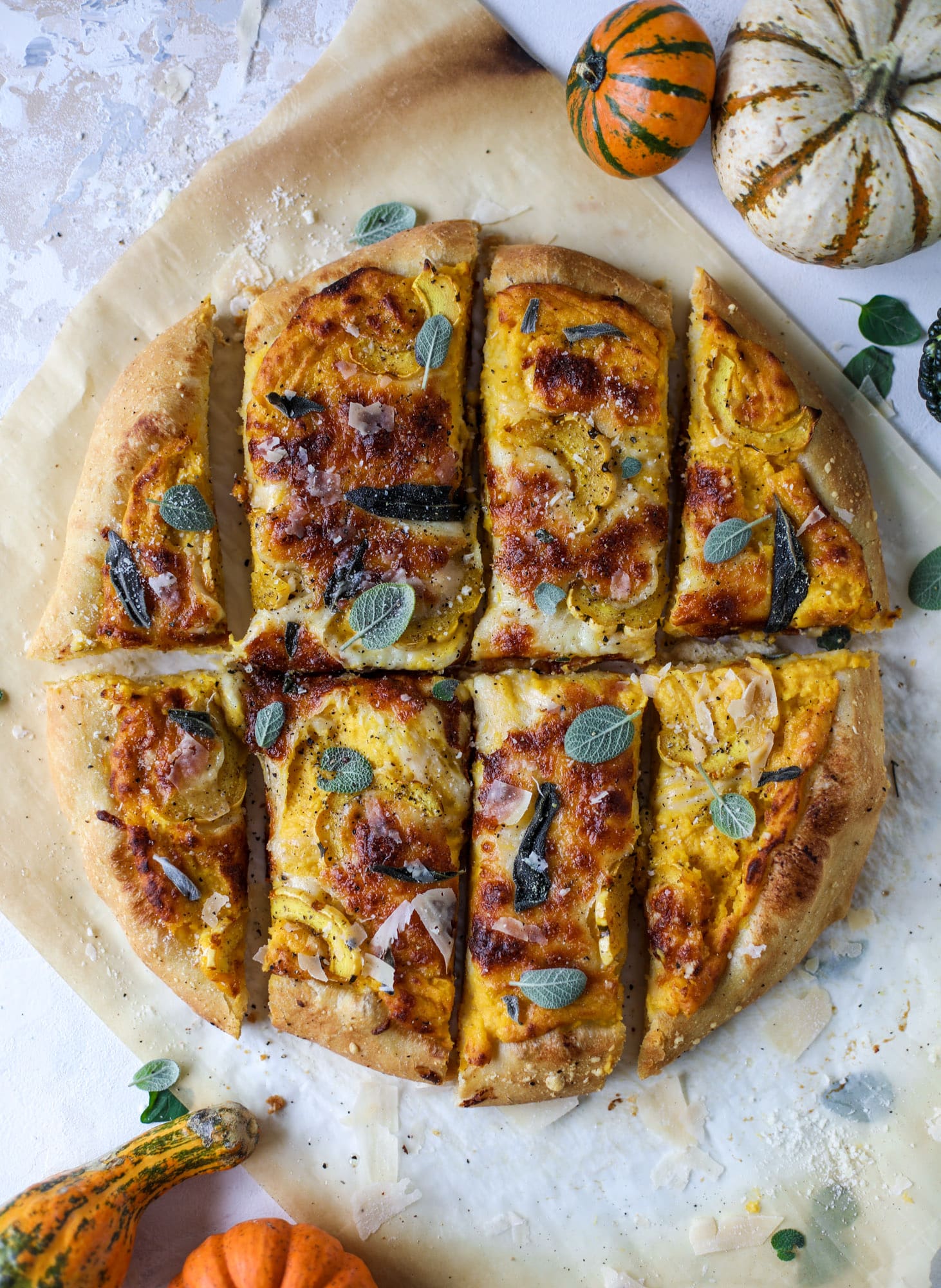 This butternut squash pizza has all the perfect tastes of fall in a pizza! Creamy butternut squash base, sharp parmesan cheese, crispy, fresh sage - it's all these and so super flavorful. It's easy too! I howsweeteats.com #butternutsquash #pizza