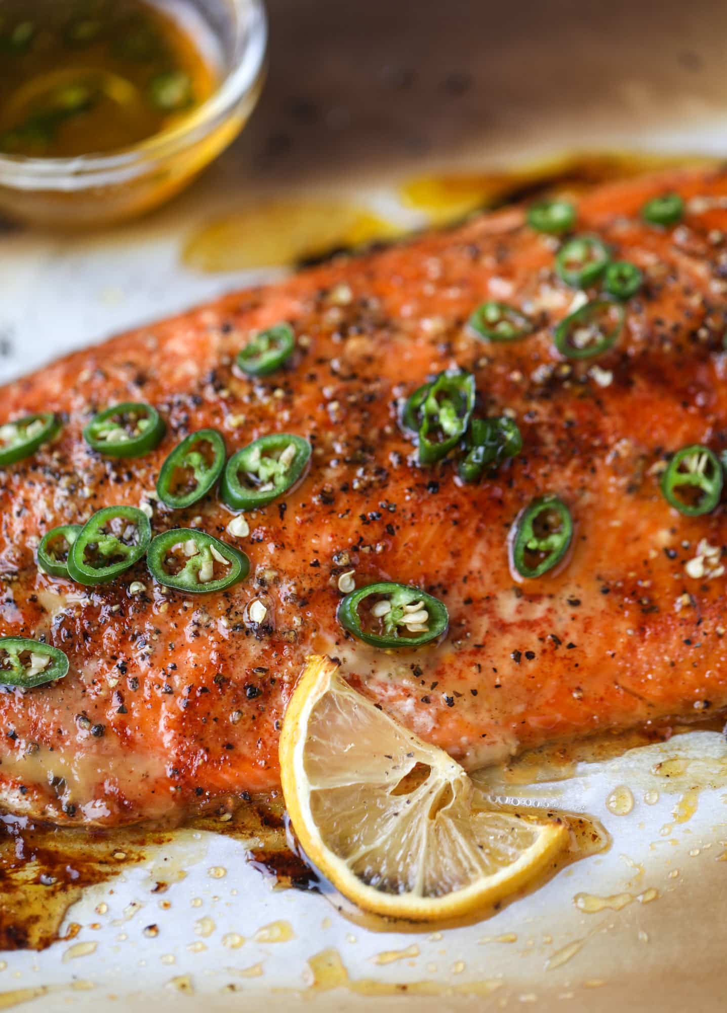 This hot honey salmon is flakey and buttery with a hint of heat and a sprtiz of lemon. It's an easy weeknight meal and is delicious on salads for lunch! I howsweeteats.com #hothoney #salmon