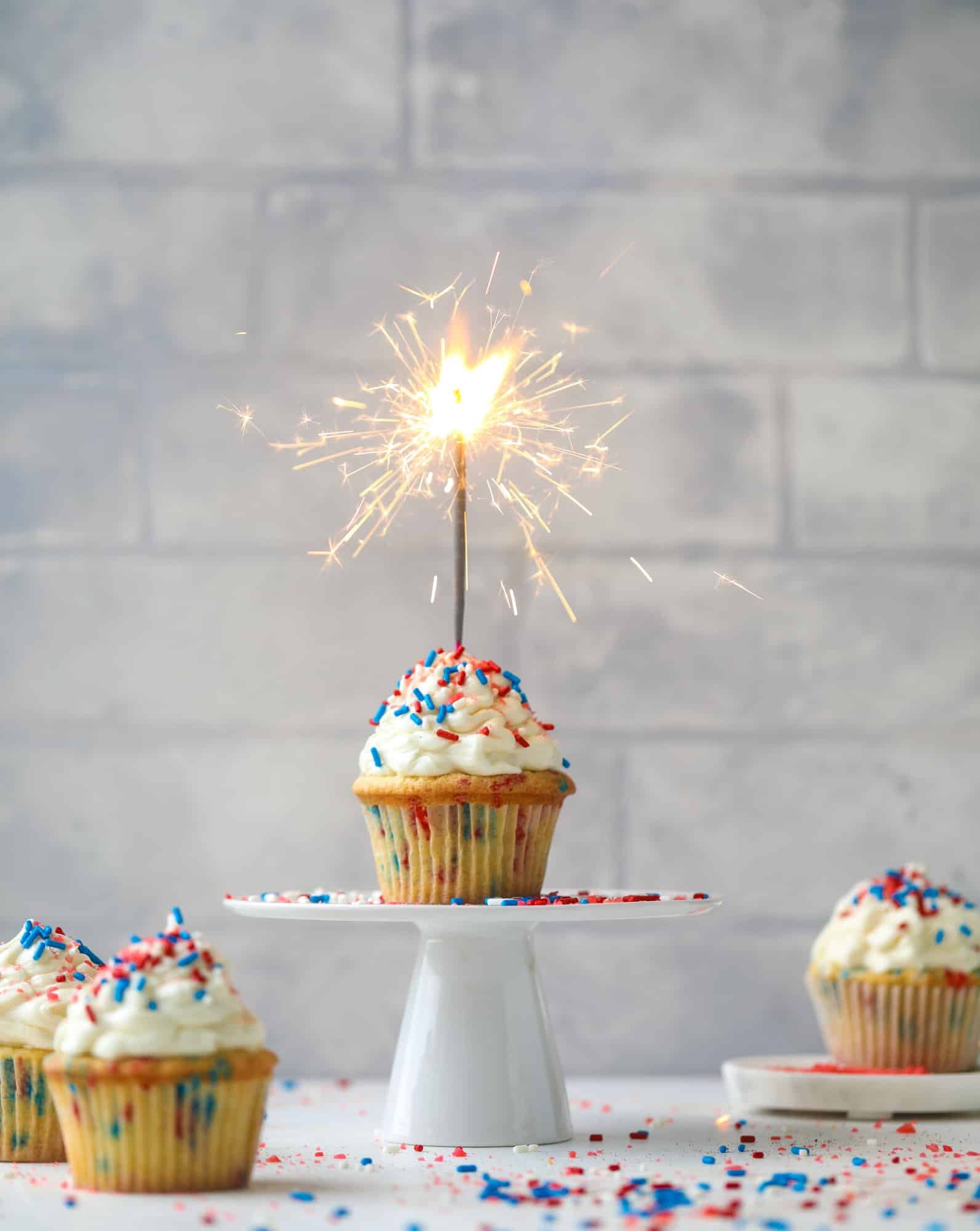 These 4th of July confetti cupcakes are super fun! Firecracker cupcakes with red, white and blue sprinkles and pop rocks candy on top for crackle! 