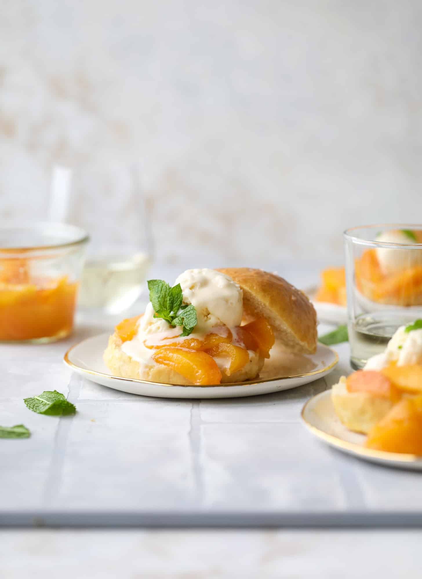 Prosecco peach shortcakes are out of these world! Prosecco poached peaches with vanilla ice cream on homemade salted brioche buns. To die for.