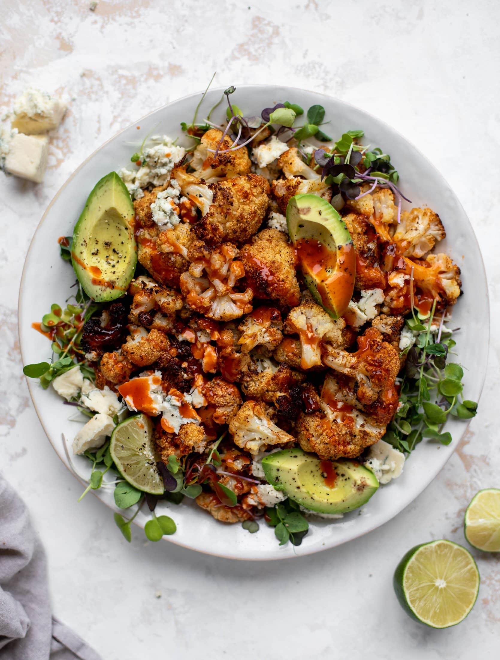 This crispy buffalo cauliflower is loaded with flavor! Serve with avocado and smoked blue cheese - you will want to eat this everyday!