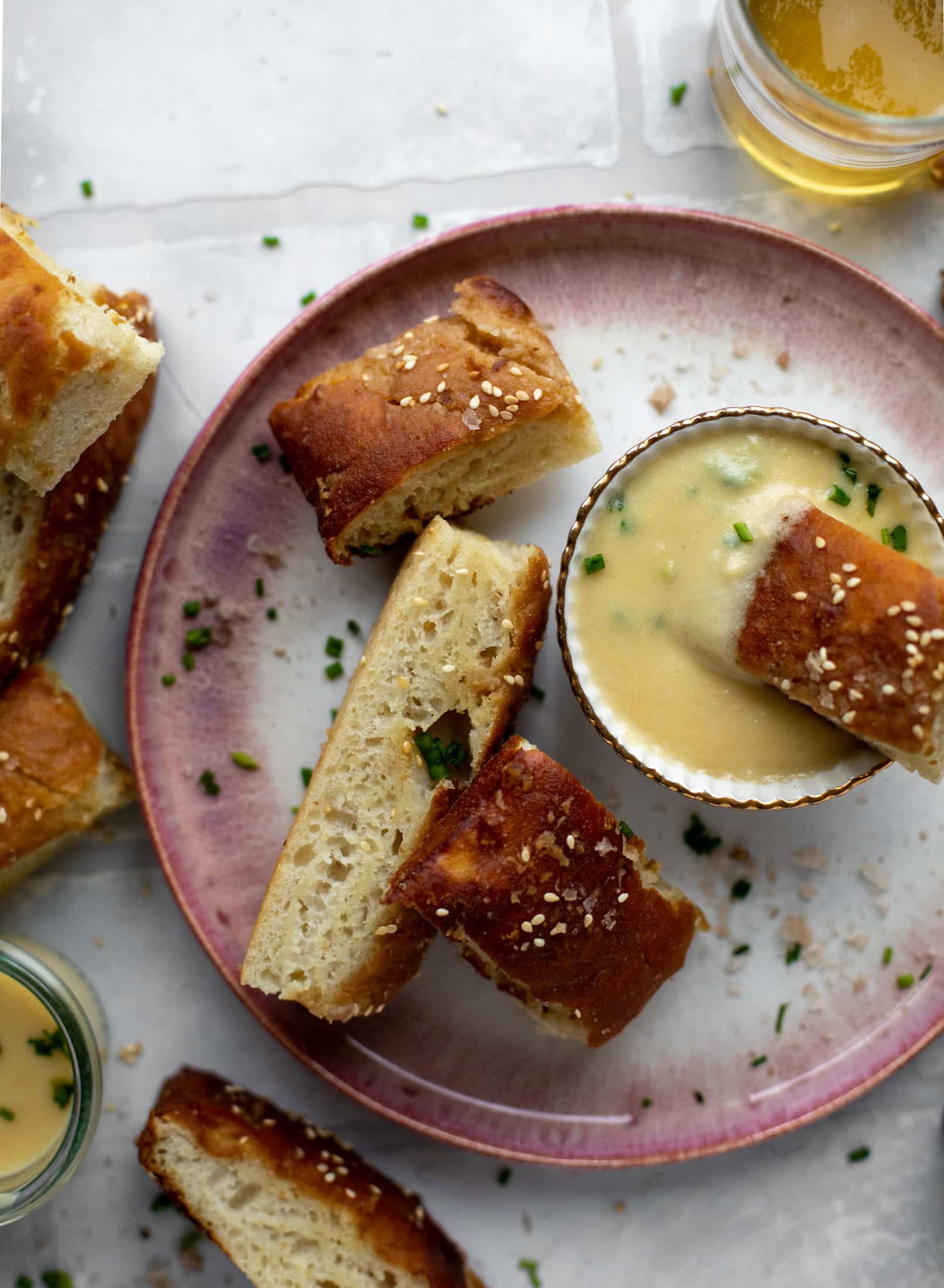 This sesame pretzel focaccia bread is amazing! Almost like a soft pretzel with crispy edges. Serve with a delicious dijon beer cheese.