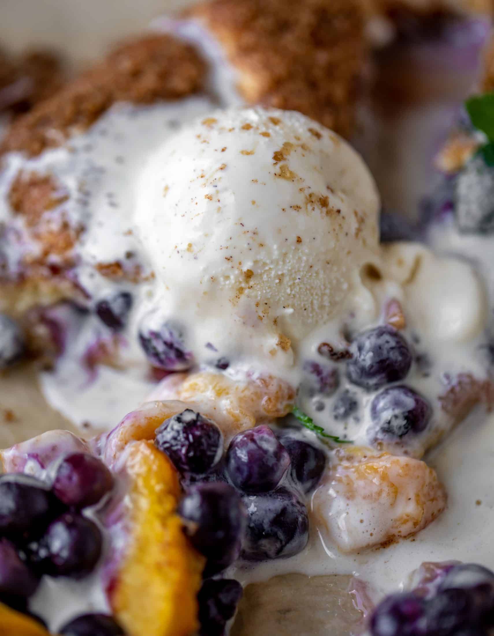 blueberry peach galette with cinnamon sugar galette topped with ice cream and fresh mint