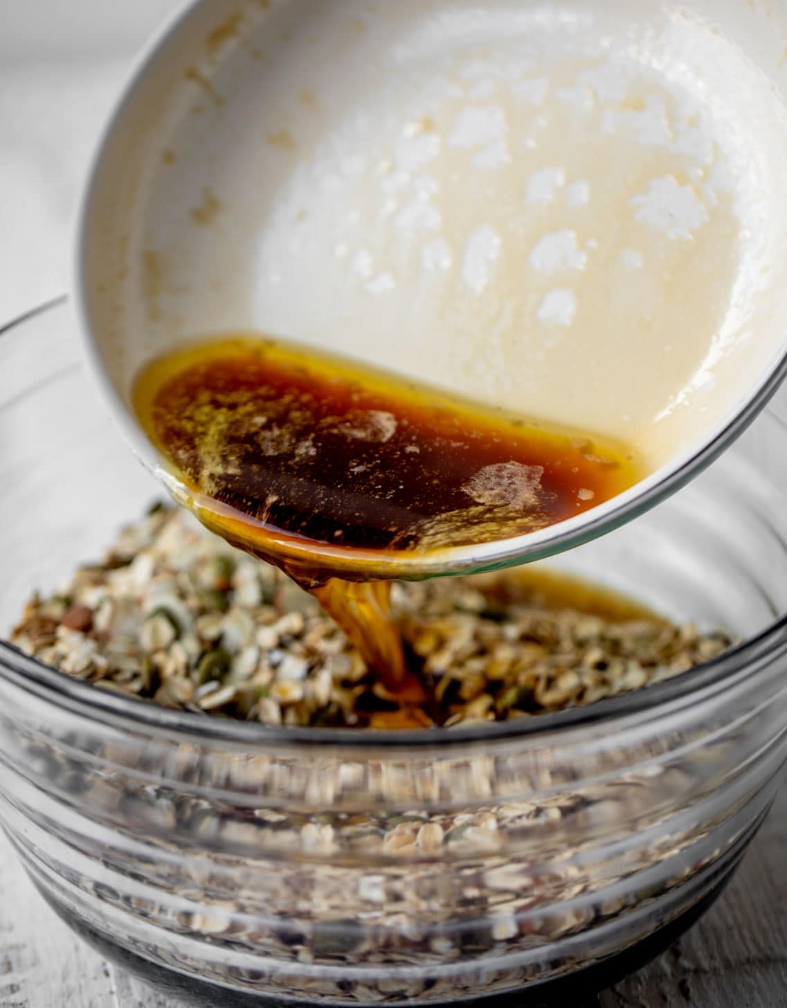 pouring maple syrup into the granola