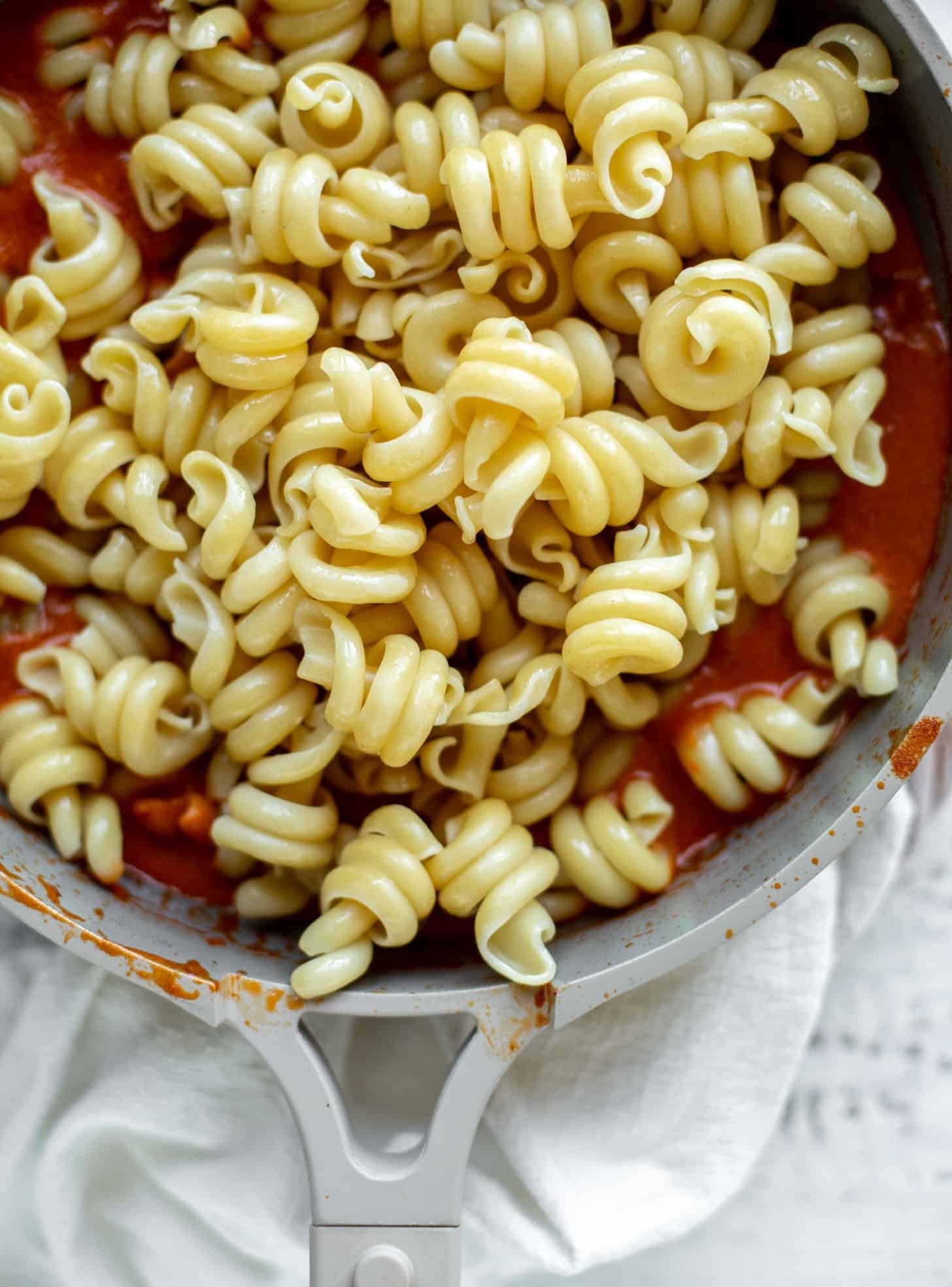 tossing pasta in vodka sauce