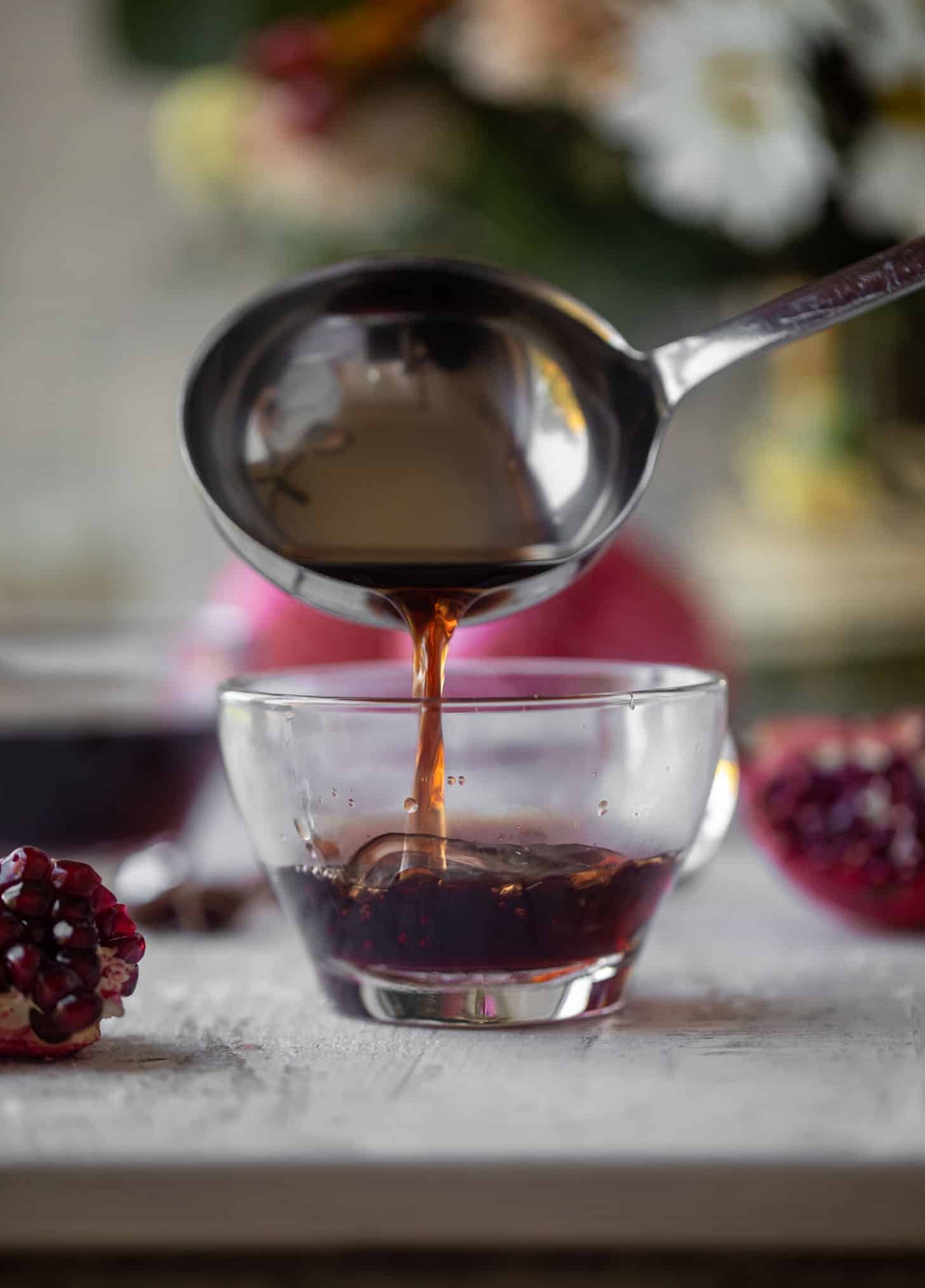 pouring hot pomegranate cider in mug