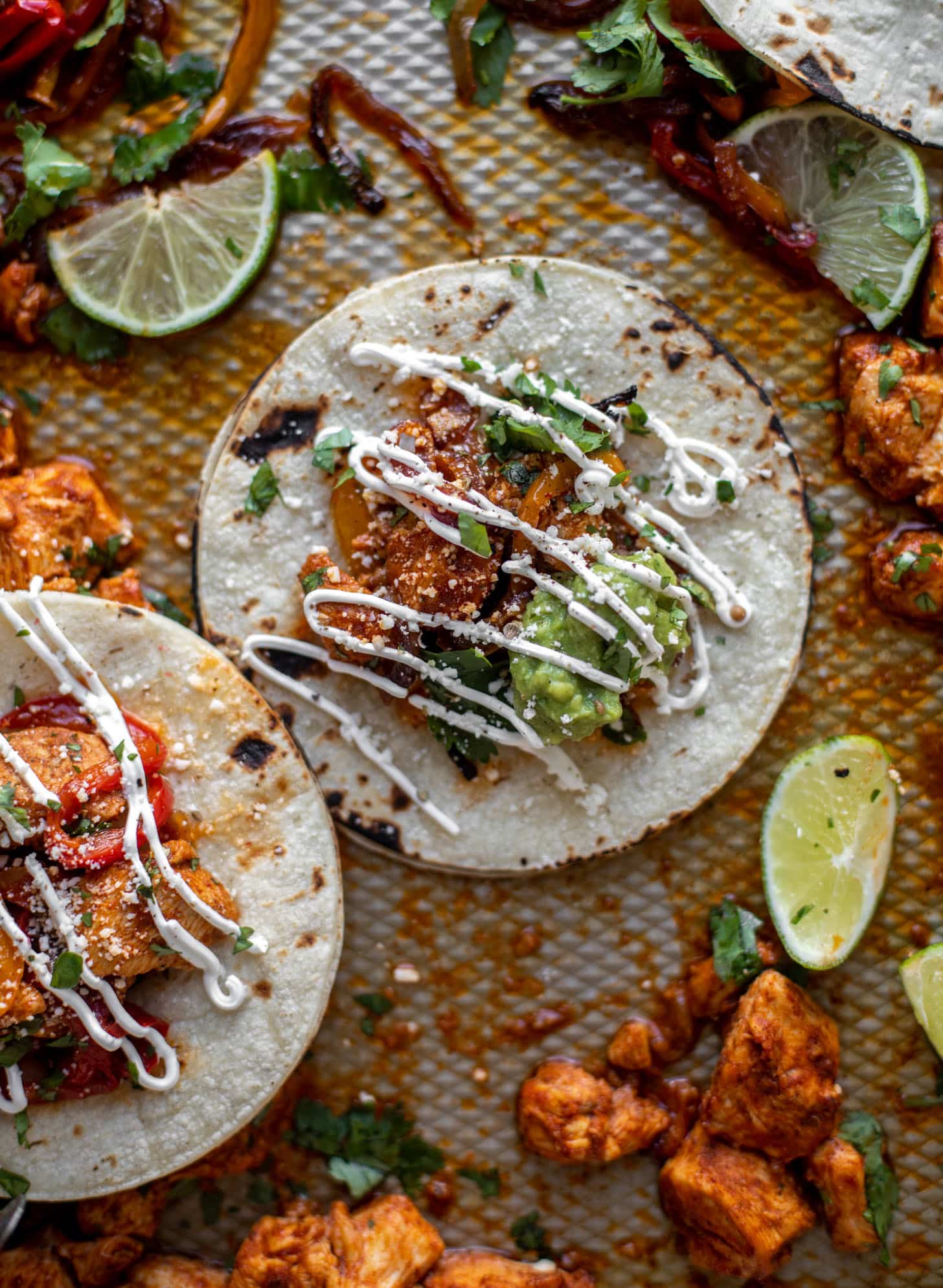 sheet pan chicken fajitas on tortillas with sour cream