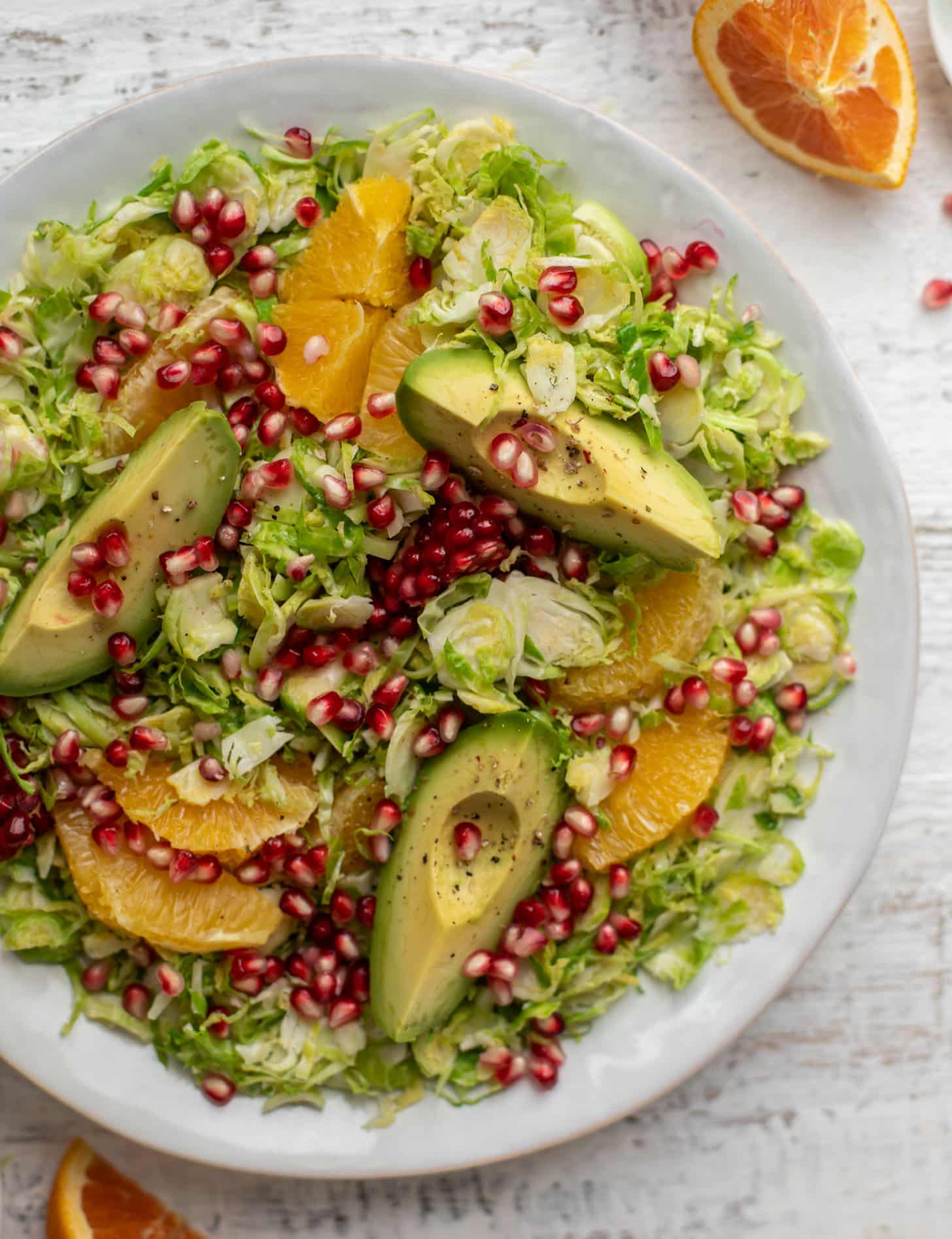 shredded citrus brussels sprouts salad with avocado and pomegranate