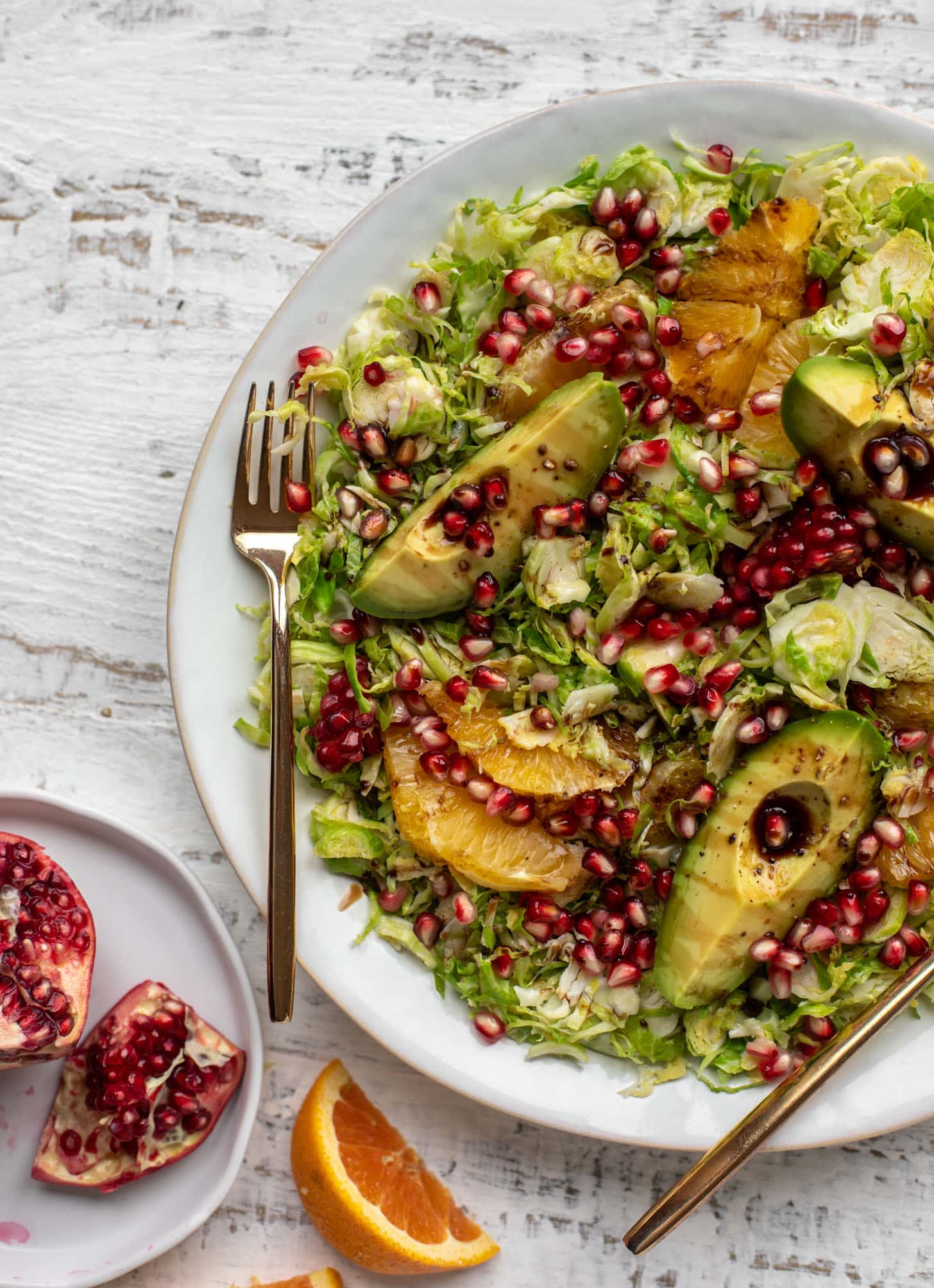 shredded citrus brussels sprouts salad with avocado and pomegranate