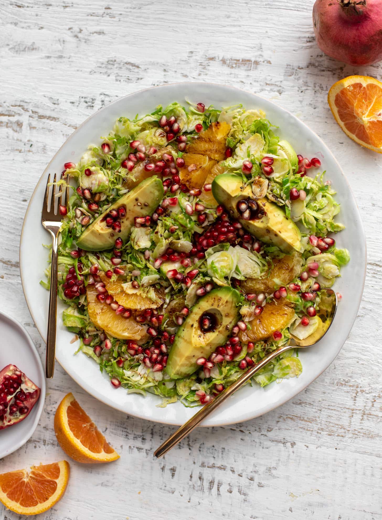 shredded citrus brussels sprouts salad with avocado and pomegranate