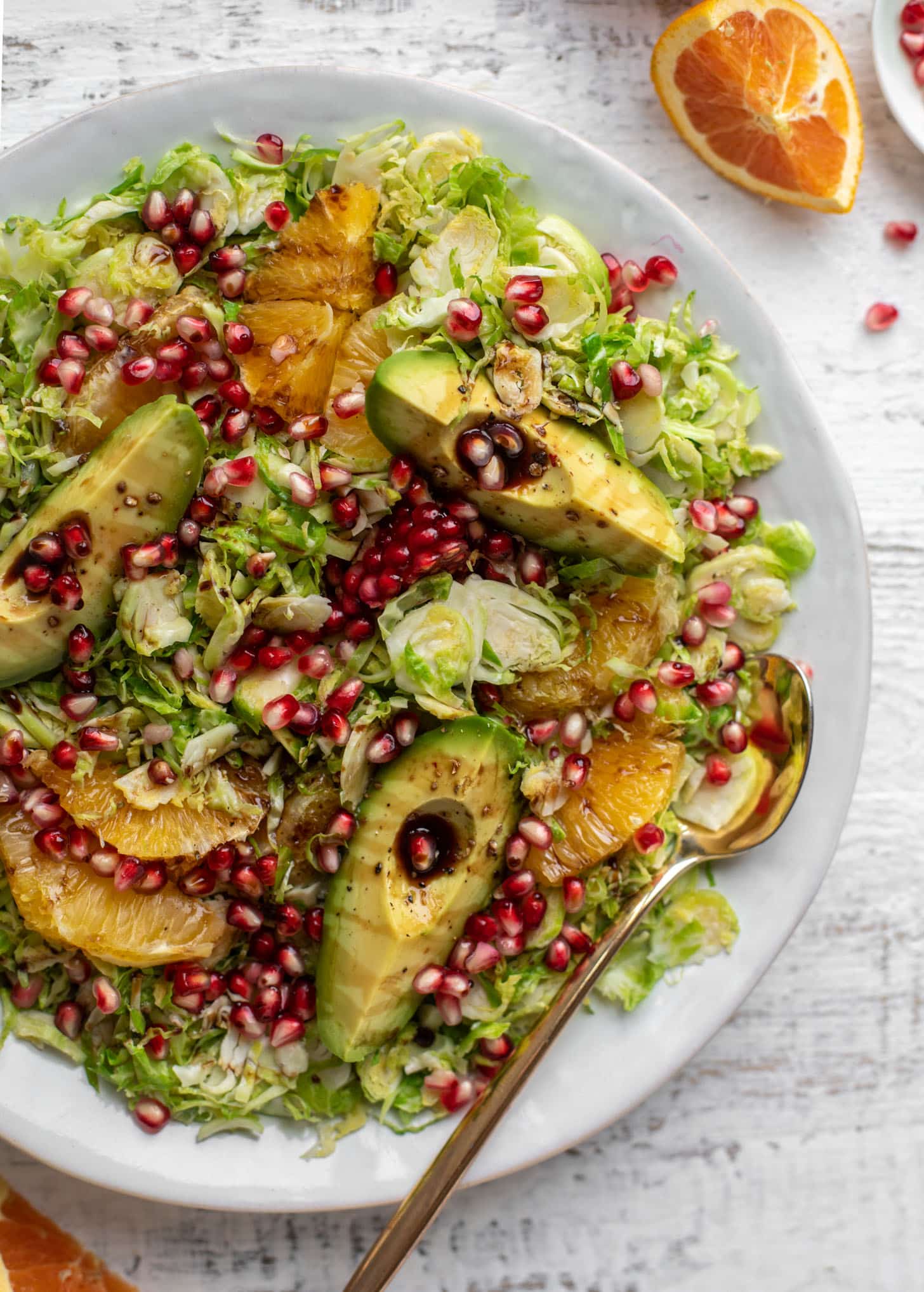 shredded citrus brussels sprouts salad with avocado and pomegranate