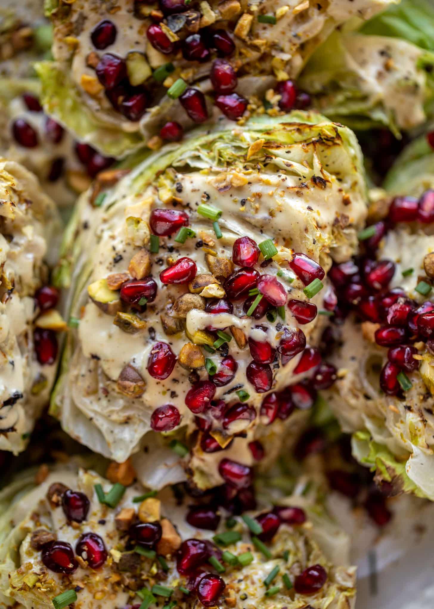 broiled wedge salad with pomegranates and pistachios
