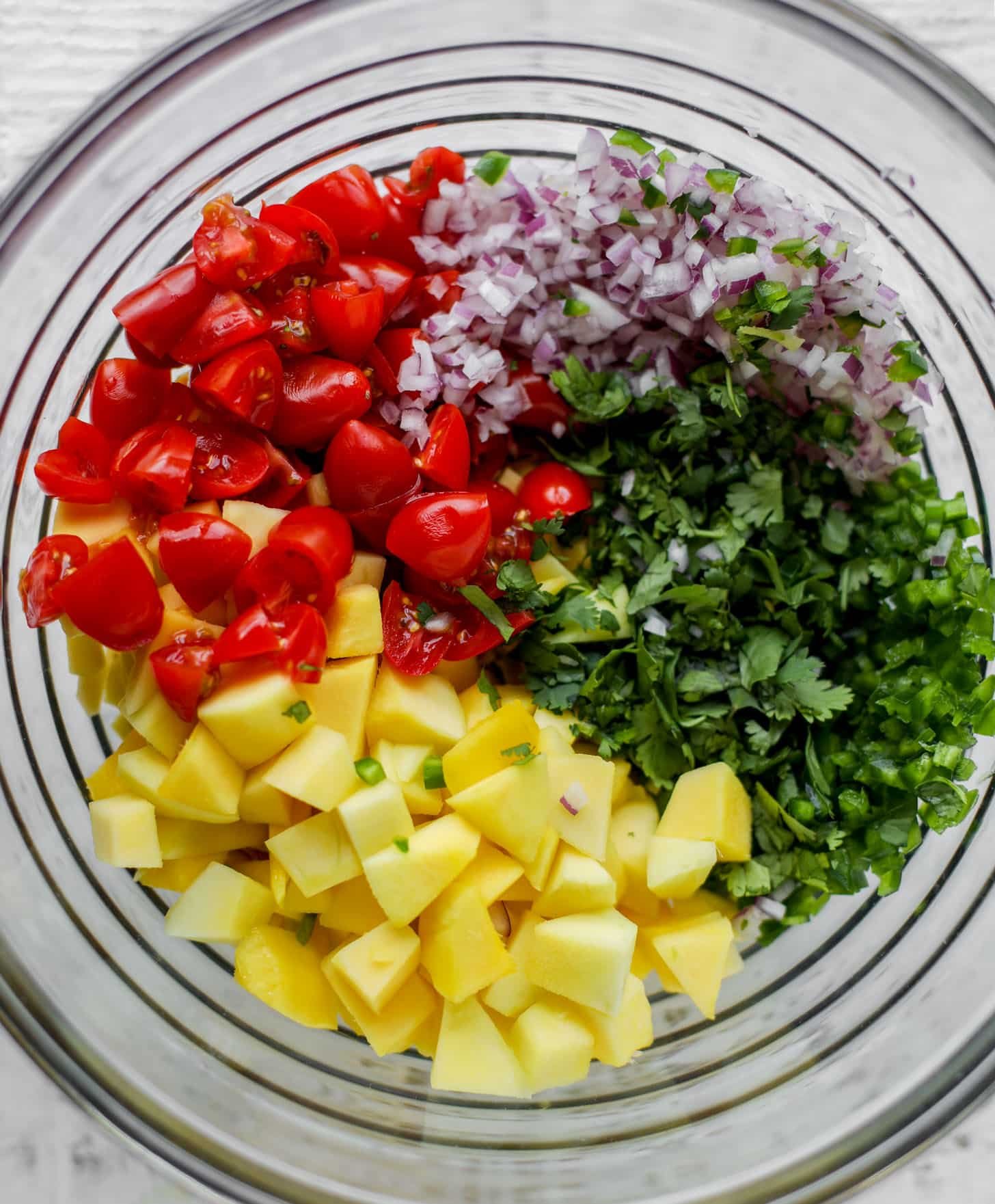 tomatoes, mango, onion, cilantro in a bowl
