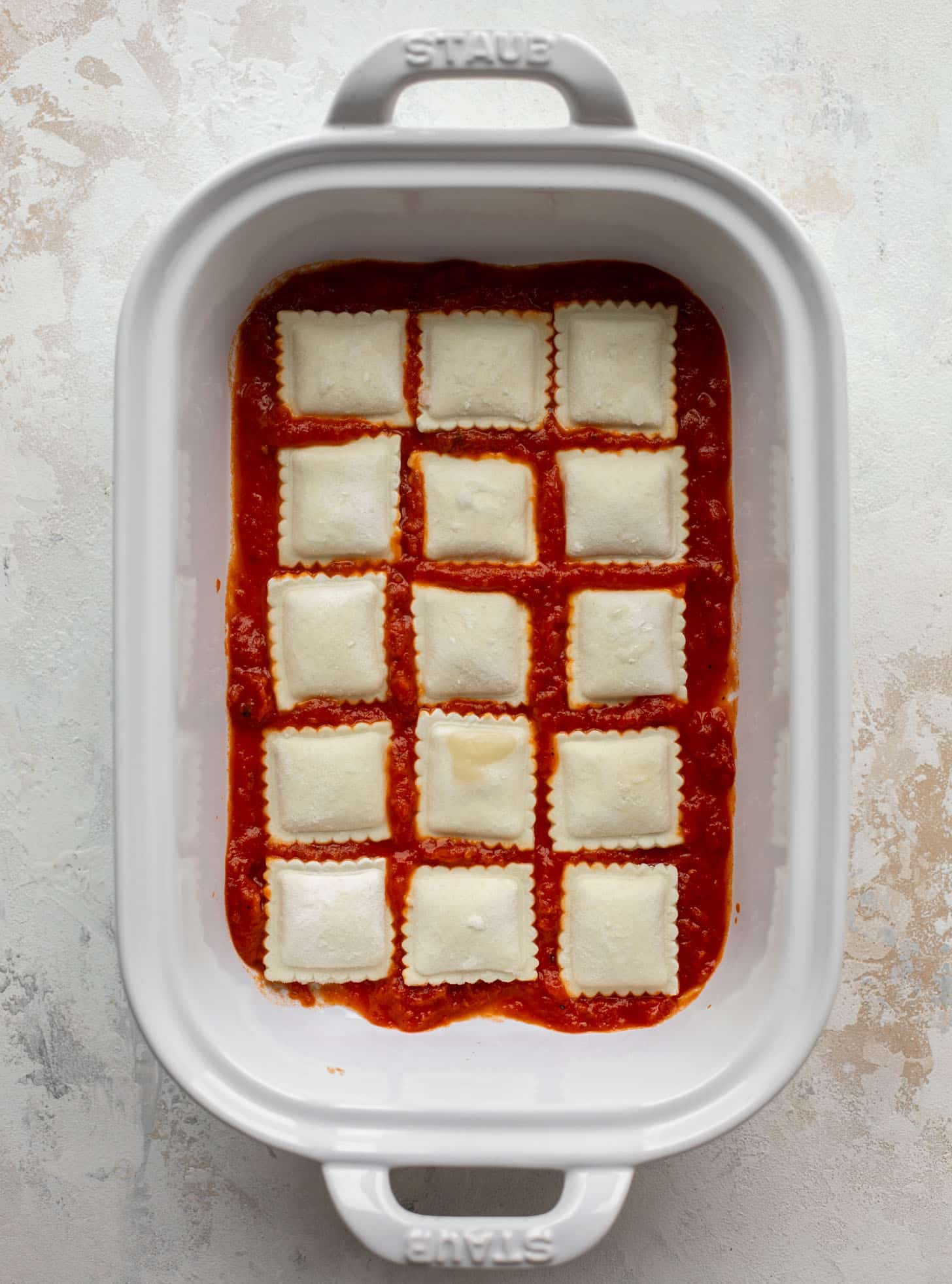 baking dish with marinara and ravioli