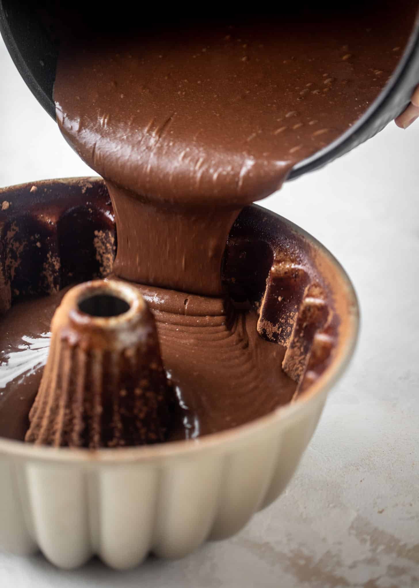 pouring cake batter into a bundt pan