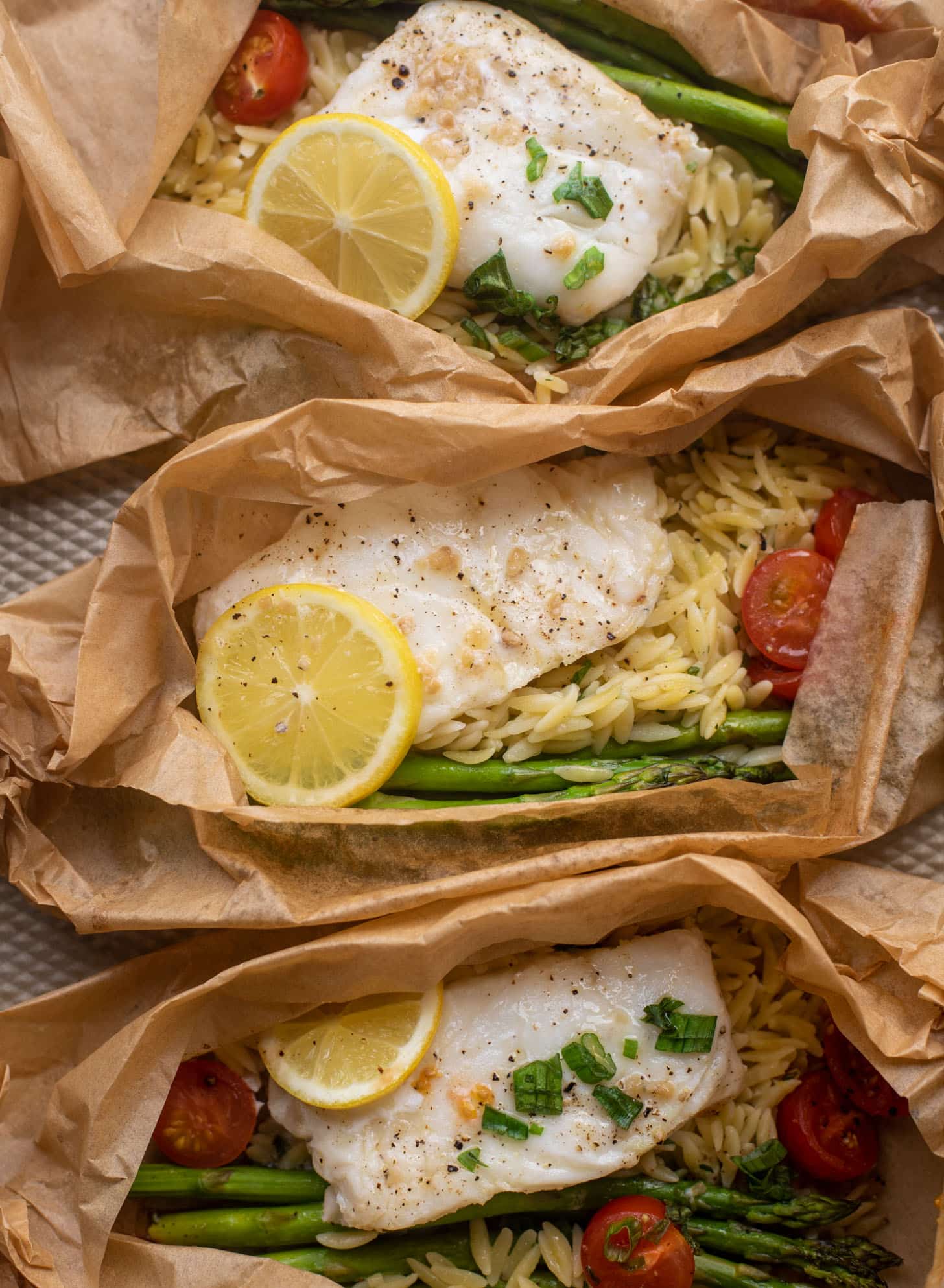 lemon garlic butter orzo and fish in parchment packet
