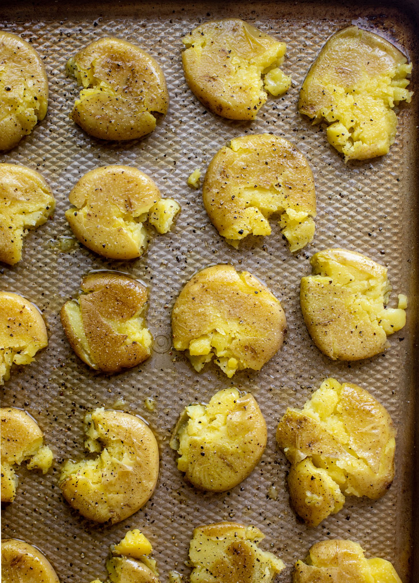 crispy smashed potatoes on a baking sheet