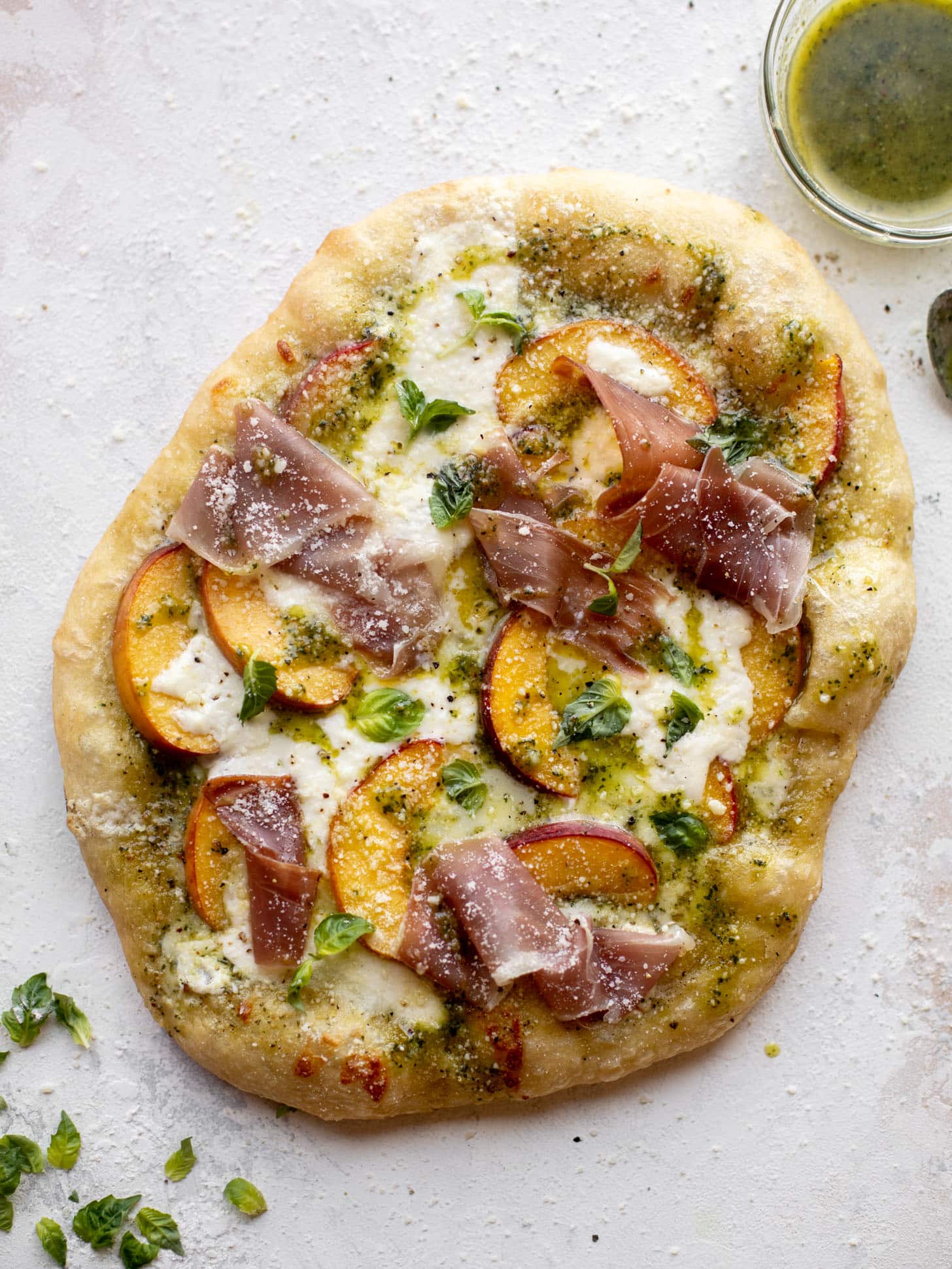 pesto peach pizza with prosciutto and burrata